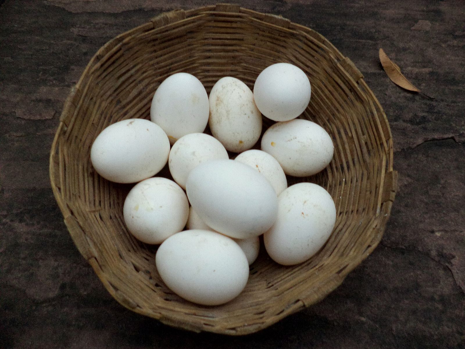 Cesta de palha com ovos brancos